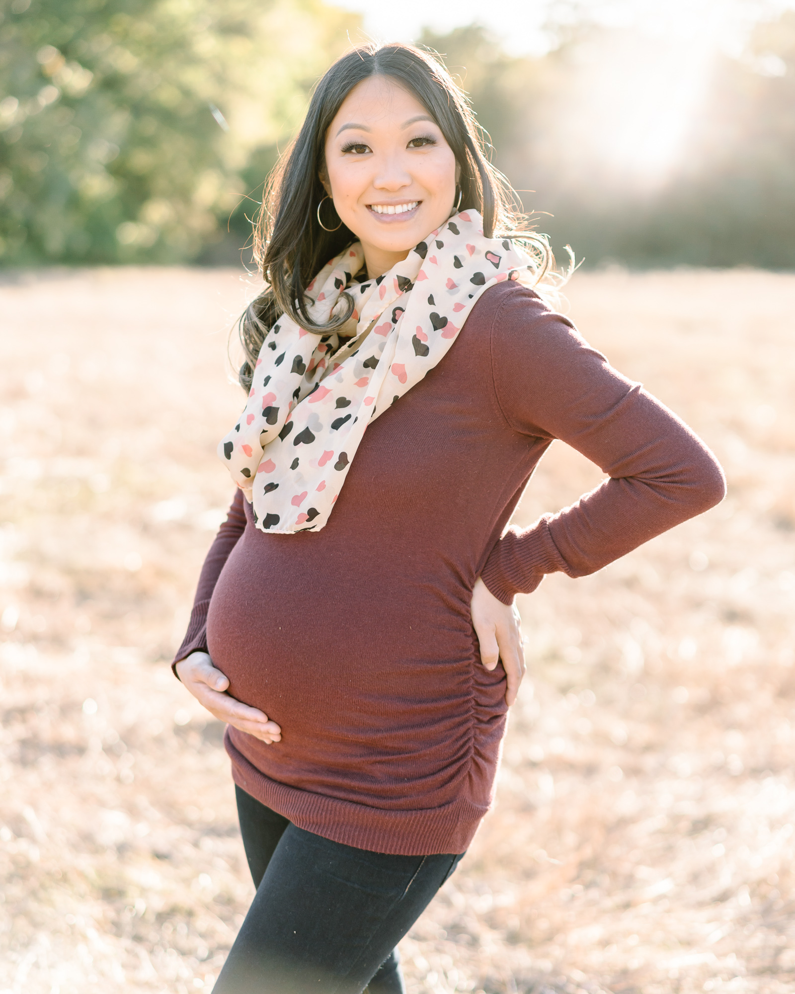 Pregnant woman holding her belly and smiling