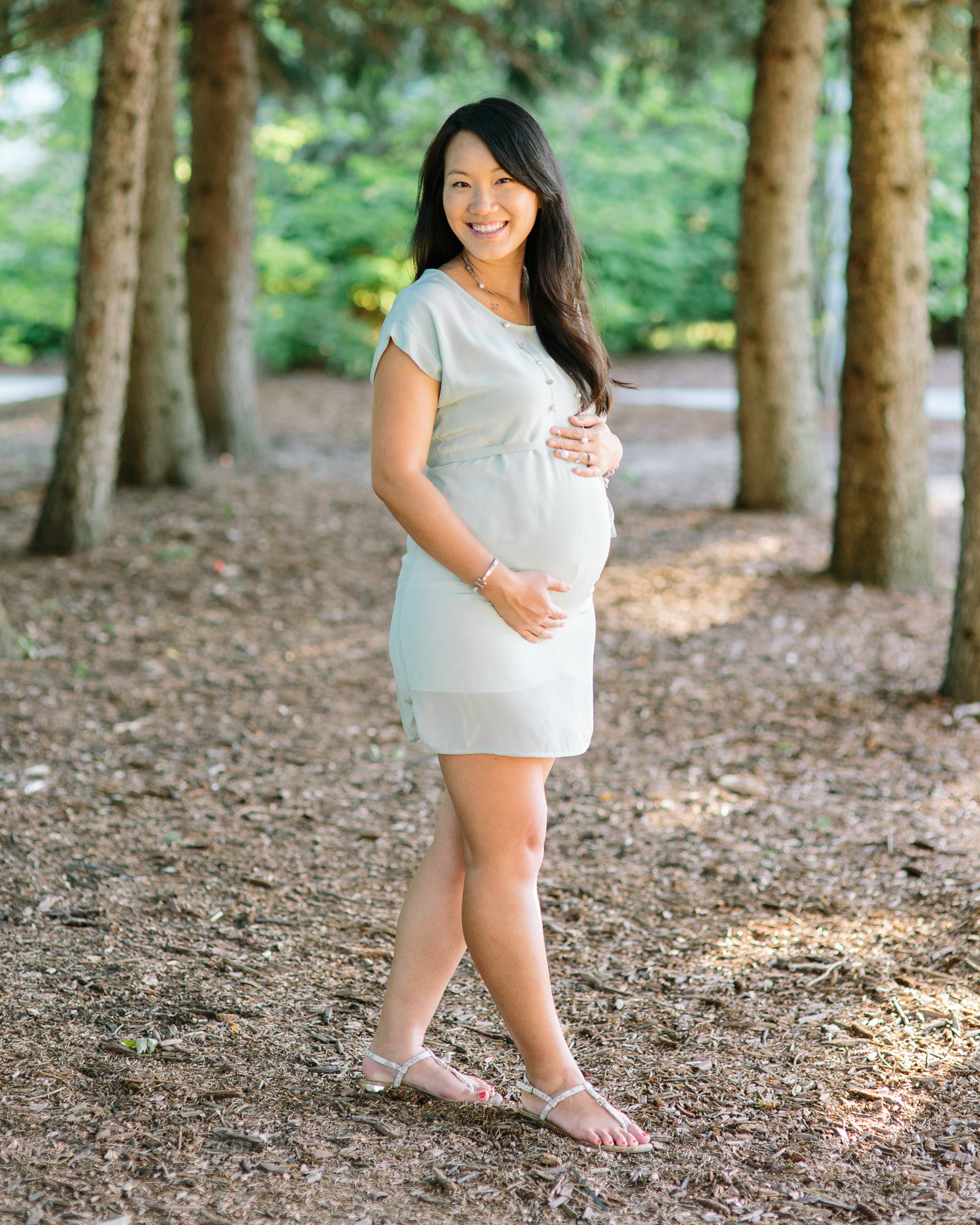 Expectant mother holding her belly in a forest