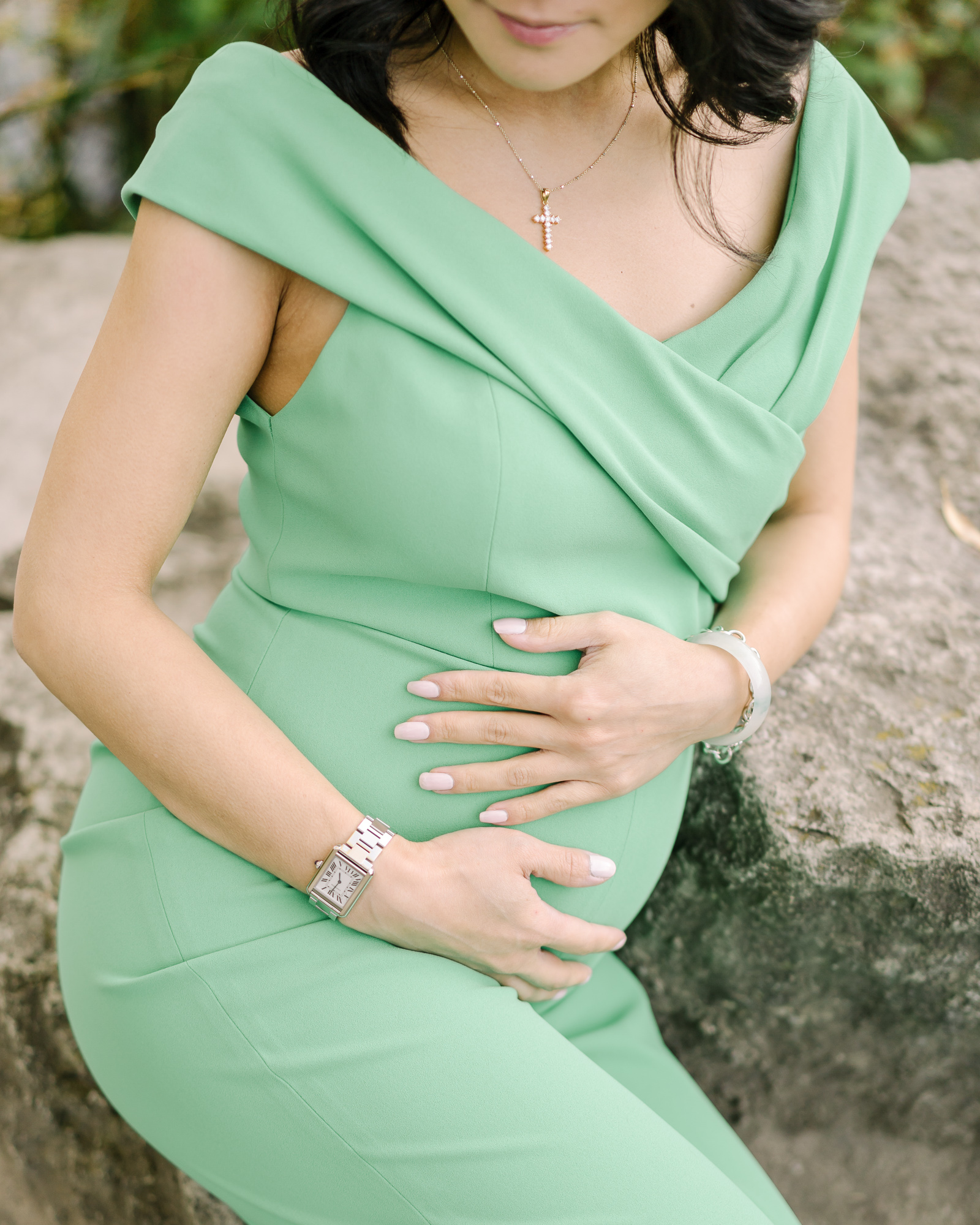 Pregnant woman holding her belly while sitting
