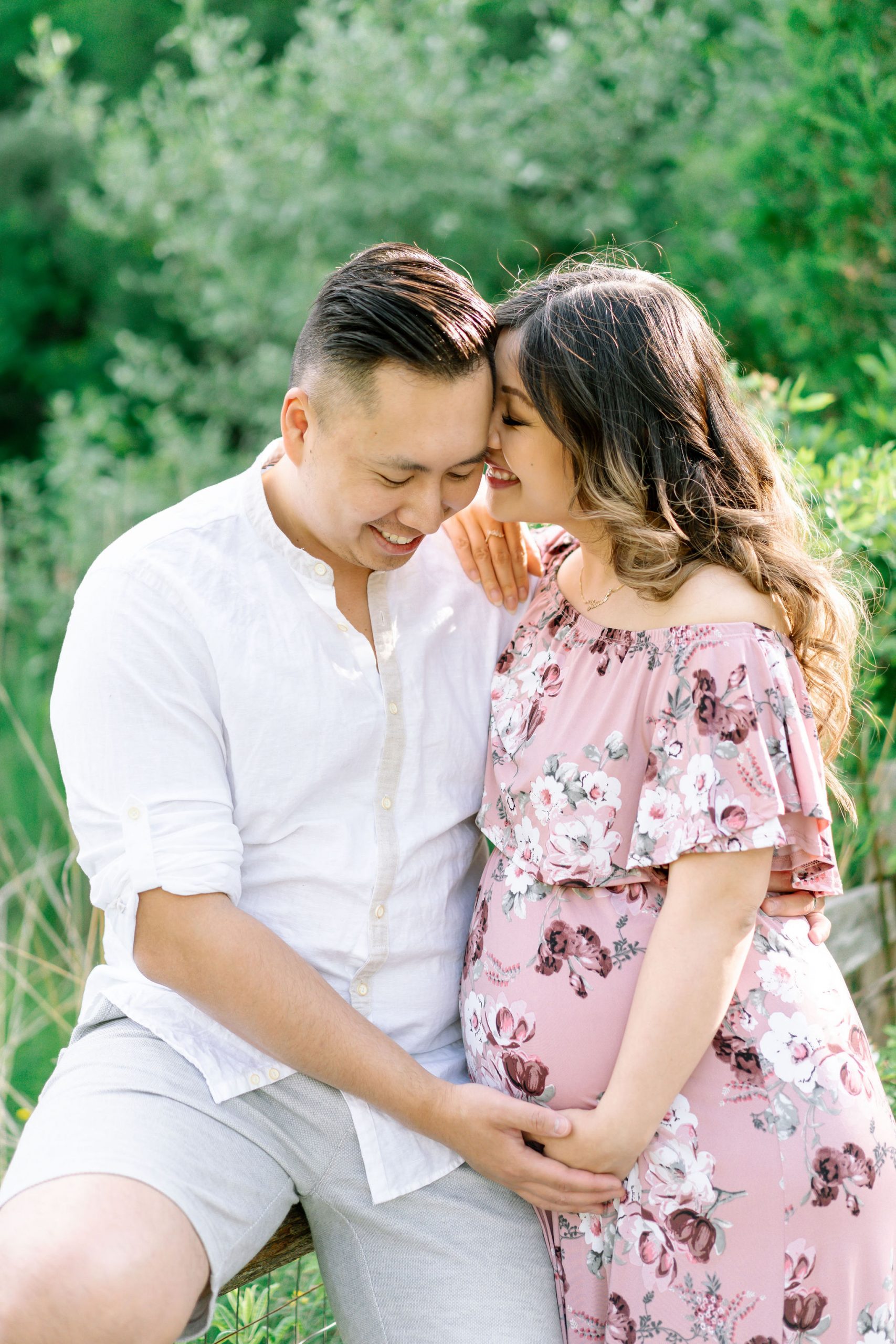 Pregnant woman laughing with husband during their maternity session with Joee Wong.